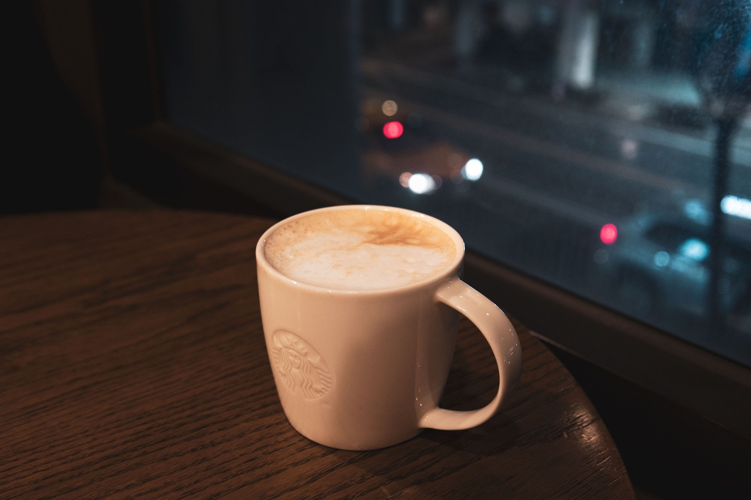 A cup of coffee by a rainy window